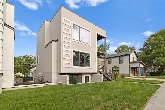 4544 Bell St, Kansas City, MO 64111 - view of front of house with a front lawn, stucco siding, and stairway