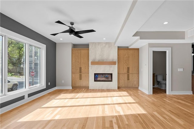 4544 Bell St, Kansas City, MO 64111 - unfurnished living room featuring baseboards, a large fireplace, light wood-style flooring, and recessed lighting