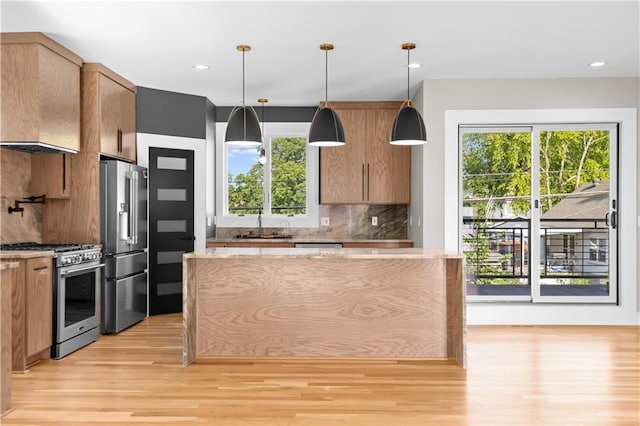 4544 Bell St, Kansas City, MO 64111 - kitchen with appliances with stainless steel finishes, light wood finished floors, tasteful backsplash, healthy amount of natural light, and recessed lighting