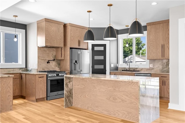 4544 Bell St, Kansas City, MO 64111 - kitchen featuring stainless steel appliances, tasteful backsplash, light wood-style flooring, light stone counters, and recessed lighting