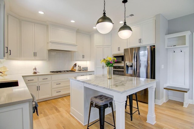 14485 S Houston St, Olathe, KS 66061 - kitchen with stainless steel appliances, decorative backsplash, light wood finished floors, a kitchen breakfast bar, and recessed lighting