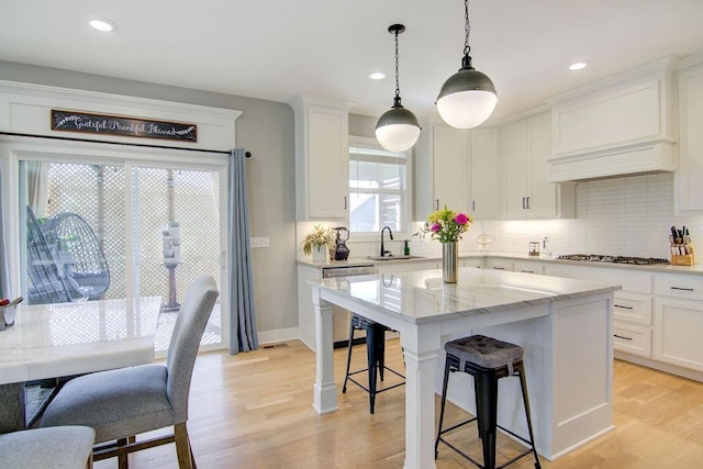 14485 S Houston St, Olathe, KS 66061 - kitchen featuring appliances with stainless steel finishes, a sink, a kitchen breakfast bar, white cabinets, and recessed lighting