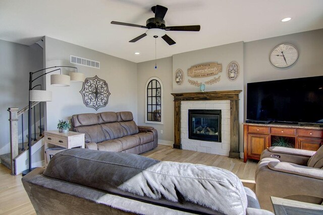 14485 S Houston St, Olathe, KS 66061 - living area with light wood-style floors, ceiling fan, a stone fireplace, recessed lighting, and stairs