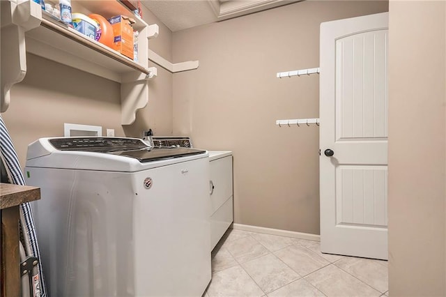 10601 N Euclid Ave, Kansas City, MO 64155 - washroom featuring washing machine and clothes dryer, light tile patterned floors, and baseboards