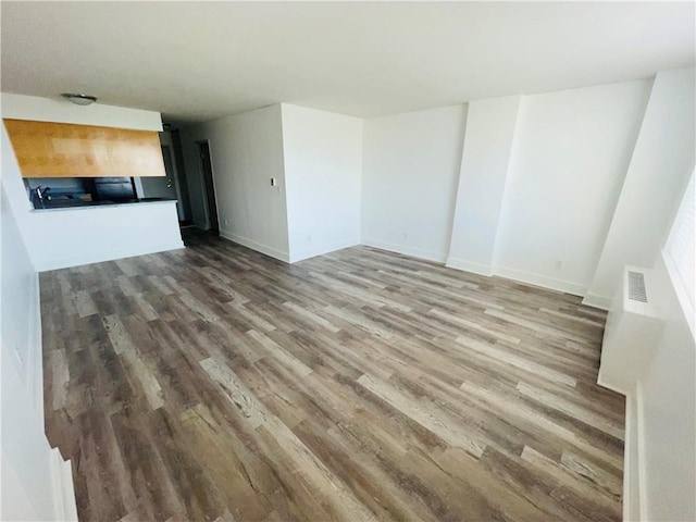 600 E 8th St Unit 11L, Kansas City, MO 64106 - unfurnished living room with wood finished floors and baseboards