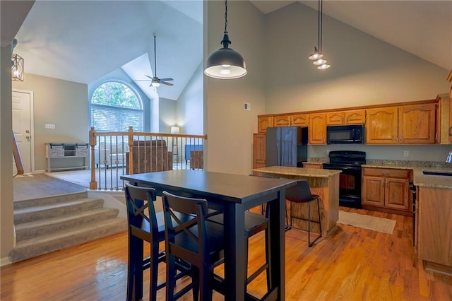 7500 N Oakland Ave, Kansas City, MO 64158 - kitchen with black appliances, a sink, high vaulted ceiling, brown cabinets, and light wood finished floors
