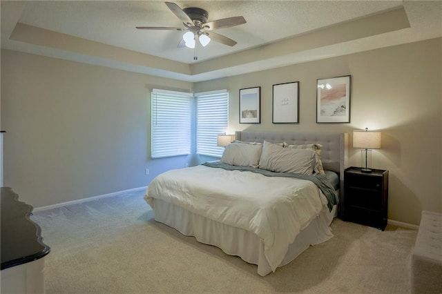7500 N Oakland Ave, Kansas City, MO 64158 - bedroom featuring a tray ceiling, light carpet, baseboards, and ceiling fan
