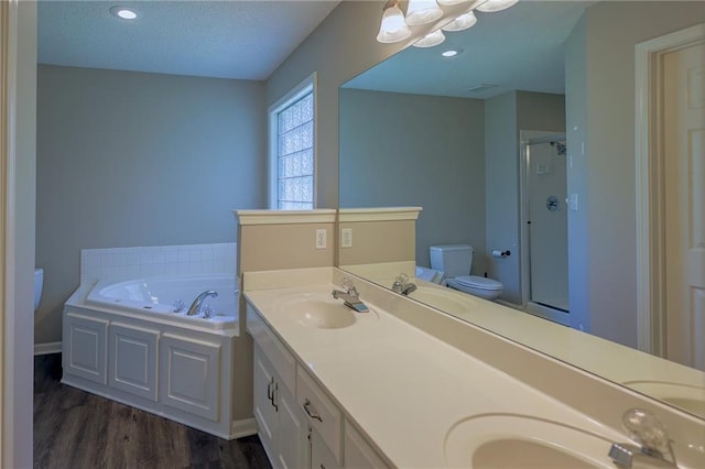 7500 N Oakland Ave, Kansas City, MO 64158 - bathroom with toilet, a stall shower, a bath, double vanity, and wood finished floors