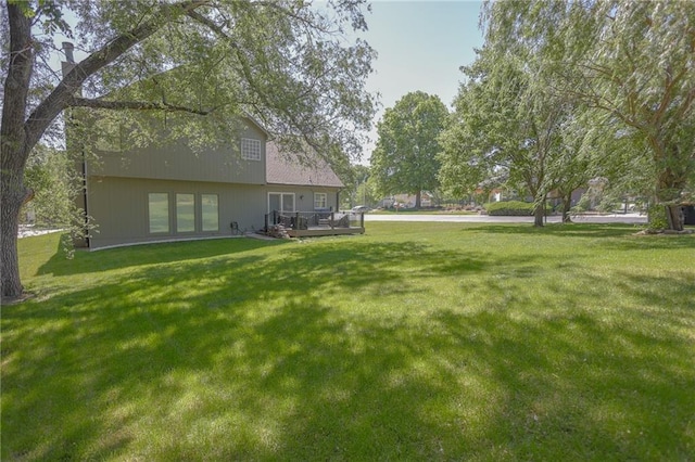 7500 N Oakland Ave, Kansas City, MO 64158 - view of grassy yard with a wooden deck