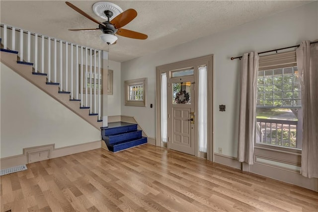 228 S Elm St, Ottawa, KS 66067 - entrance foyer featuring stairs, wood finished floors, a textured ceiling, a ceiling fan, and baseboards