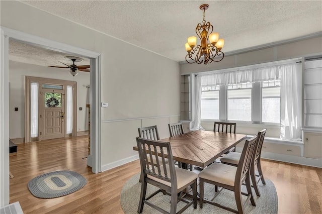 228 S Elm St, Ottawa, KS 66067 - dining area featuring a textured ceiling, a chandelier, light wood-style flooring, ceiling fan, and baseboards