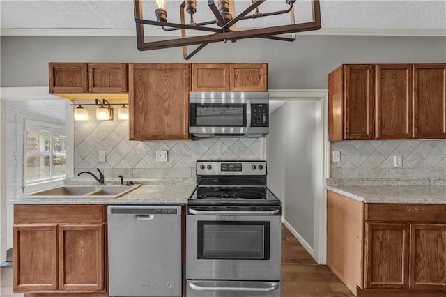 228 S Elm St, Ottawa, KS 66067 - kitchen featuring appliances with stainless steel finishes, a sink, light countertops, dark wood-type flooring, and ornamental molding