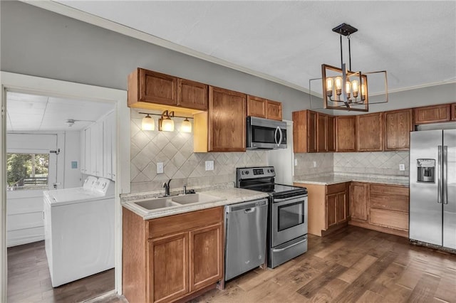 228 S Elm St, Ottawa, KS 66067 - kitchen with stainless steel appliances, a sink, brown cabinets, light countertops, and ornamental molding