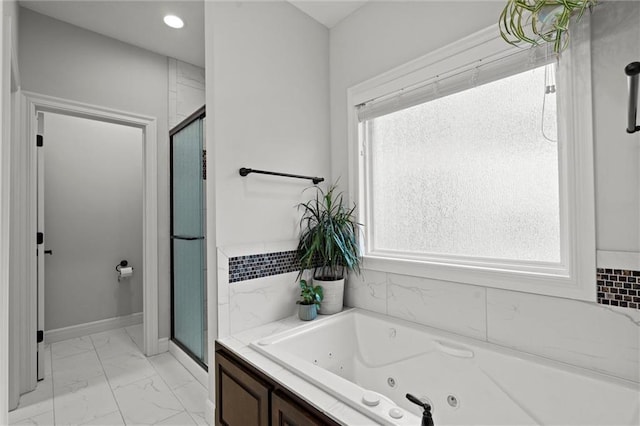 3205 SW Mary St, Lees Summit, MO 64081 - bathroom featuring marble look tiles, a shower stall, a jetted tub, and baseboards