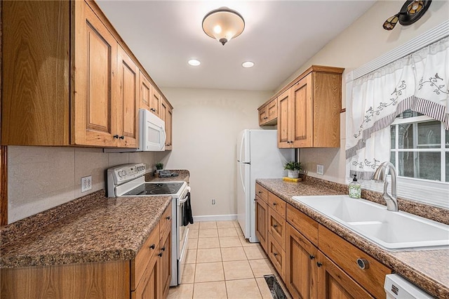 614 S 7th St, Atchison, KS 66002 - kitchen with white appliances, a sink, brown cabinets, baseboards, and light tile patterned flooring