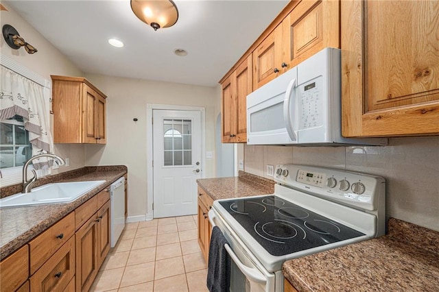 614 S 7th St, Atchison, KS 66002 - kitchen with white appliances, a sink, dark countertops, brown cabinets, and light tile patterned floors