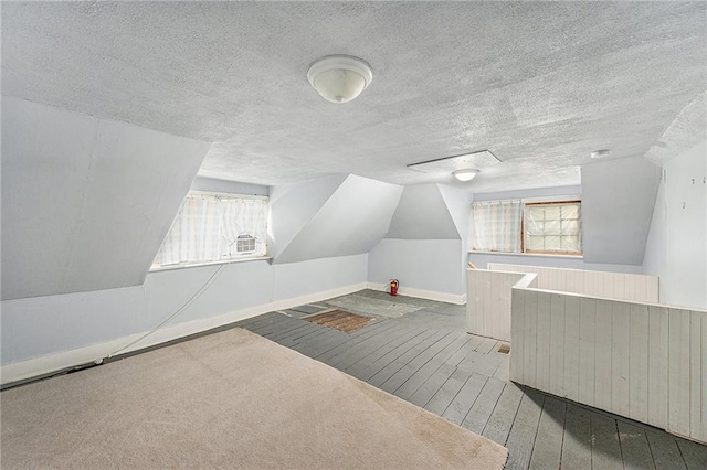 614 S 7th St, Atchison, KS 66002 - additional living space featuring hardwood / wood-style flooring, a textured ceiling, healthy amount of natural light, lofted ceiling, and baseboards