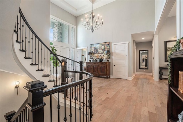 4112 W 156th St, Overland Park, KS 66224 - foyer entrance with a high ceiling, stairway, a chandelier, light wood-style flooring, and baseboards