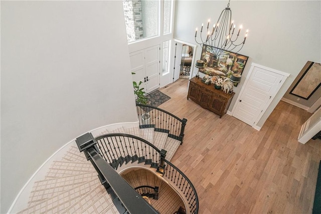 4112 W 156th St, Overland Park, KS 66224 - stairs featuring a towering ceiling, a chandelier, wood finished floors, and baseboards