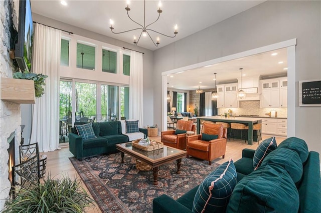 4112 W 156th St, Overland Park, KS 66224 - living room featuring light wood-style floors, recessed lighting, a chandelier, a towering ceiling, and a fireplace