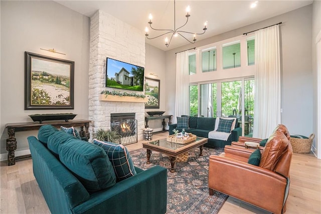 4112 W 156th St, Overland Park, KS 66224 - living room with a chandelier, wood finished floors, a towering ceiling, and a stone fireplace
