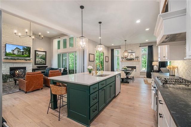 4112 W 156th St, Overland Park, KS 66224 - kitchen featuring green cabinets, a stone fireplace, a sink, appliances with stainless steel finishes, and backsplash