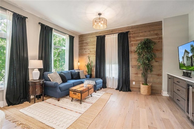 4112 W 156th St, Overland Park, KS 66224 - living area with wood walls, a chandelier, light wood-style flooring, and baseboards