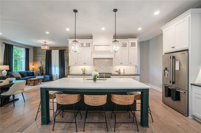 4112 W 156th St, Overland Park, KS 66224 - kitchen with high end refrigerator, backsplash, light wood-style flooring, a kitchen breakfast bar, and recessed lighting