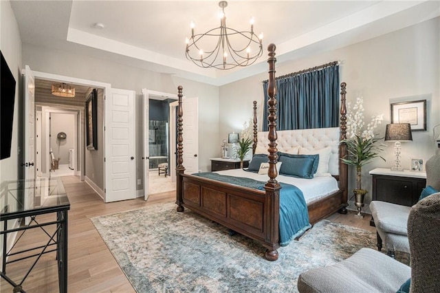 4112 W 156th St, Overland Park, KS 66224 - bedroom with a chandelier, a tray ceiling, wood finished floors, and baseboards