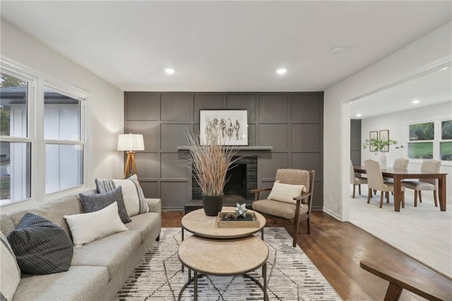 618 E 108th Ter, Kansas City, MO 64131 - living area featuring a fireplace with raised hearth, wood finished floors, and recessed lighting