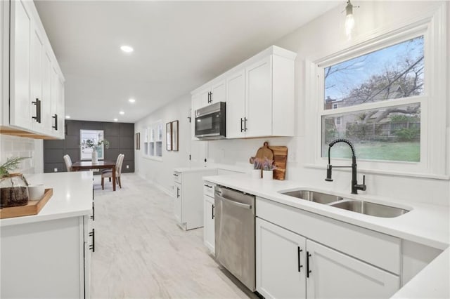 618 E 108th Ter, Kansas City, MO 64131 - kitchen featuring a sink, stainless steel dishwasher, white cabinetry, light countertops, and recessed lighting