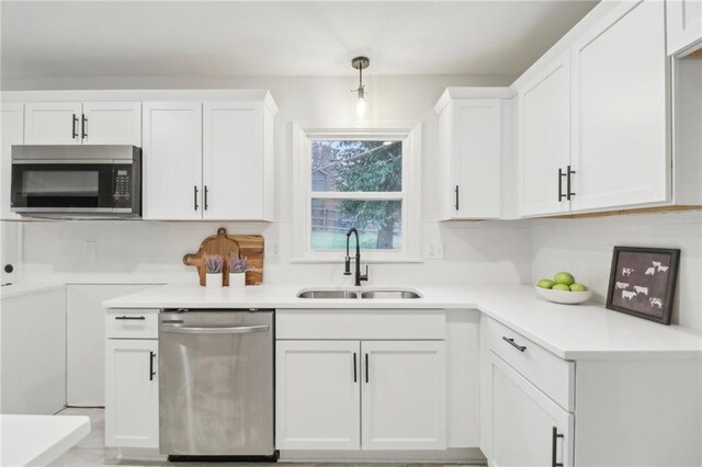 618 E 108th Ter, Kansas City, MO 64131 - kitchen featuring stainless steel appliances, a sink, white cabinetry, and light countertops