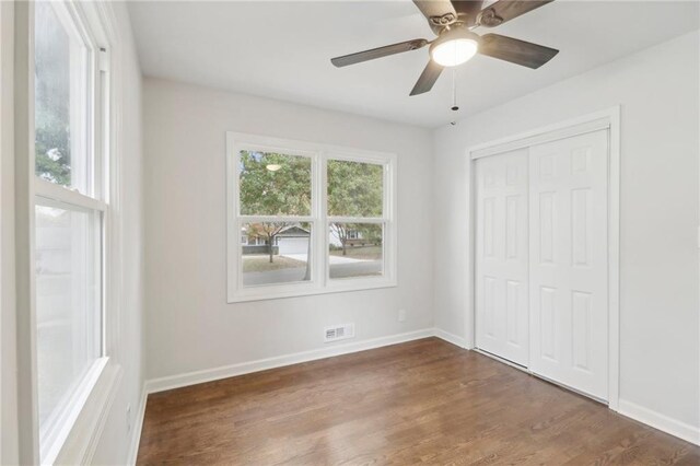 618 E 108th Ter, Kansas City, MO 64131 - unfurnished bedroom with wood finished floors, a closet, baseboards, and a ceiling fan