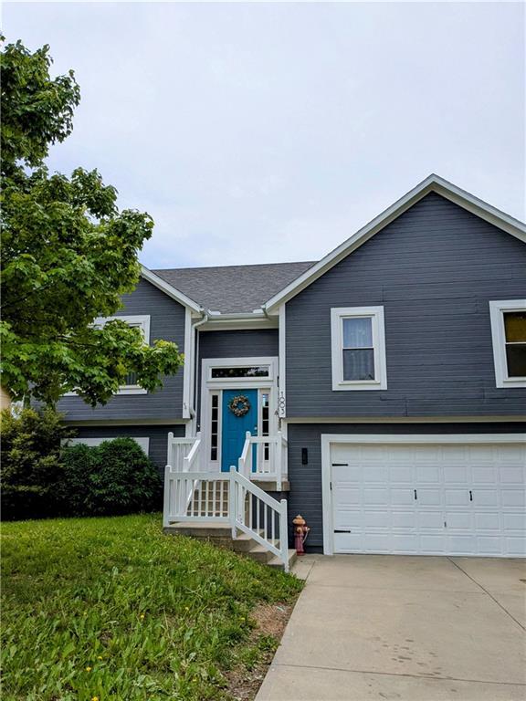 1003 Howard Ct, Louisburg, KS 66053 - split foyer home with an attached garage and driveway