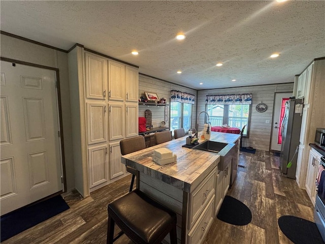 516 E 614th St, Girard, KS 66743 - kitchen with dark wood-style floors, a kitchen island with sink, wooden counters, freestanding refrigerator, and a textured ceiling