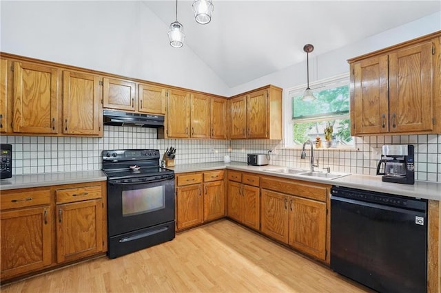 14713 W 149th Ct, Olathe, KS 66062 - kitchen with black appliances, a sink, under cabinet range hood, vaulted ceiling, and brown cabinets