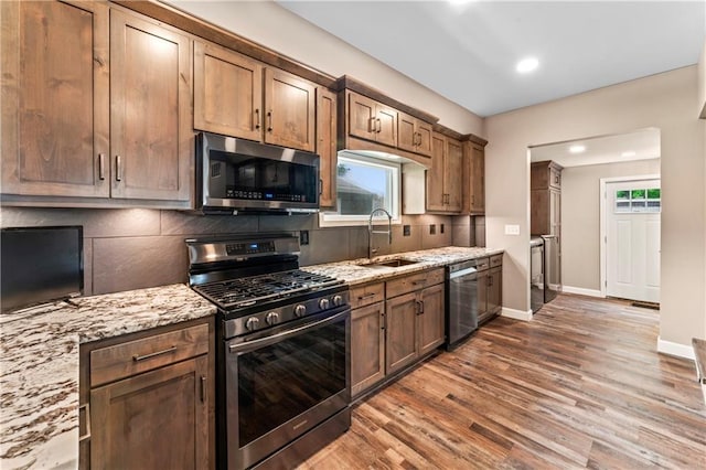 1105 S Gordon St, Concordia, MO 64020 - kitchen with stainless steel appliances, a sink, wood finished floors, decorative backsplash, and recessed lighting