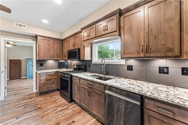 1105 S Gordon St, Concordia, MO 64020 - kitchen with appliances with stainless steel finishes, a sink, ceiling fan, backsplash, and light wood-style floors