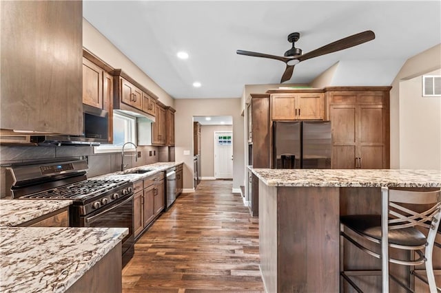 1105 S Gordon St, Concordia, MO 64020 - kitchen featuring stainless steel appliances, a sink, a ceiling fan, backsplash, and light stone countertops