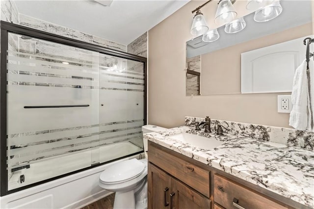 1105 S Gordon St, Concordia, MO 64020 - full bath with shower / bath combination with glass door, vanity, wood finished floors, and toilet