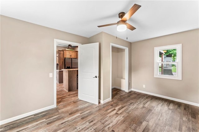 1105 S Gordon St, Concordia, MO 64020 - unfurnished bedroom featuring stainless steel refrigerator with ice dispenser, wood finished floors, and baseboards