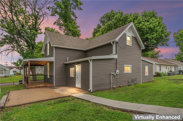 1105 S Gordon St, Concordia, MO 64020 - property exterior at dusk with a lawn, a patio area, a shingled roof, and cooling unit