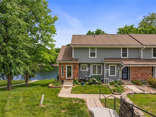 218 NE Bayview Dr, Lees Summit, MO 64064 - view of front of property with brick siding, a water view, and a front yard