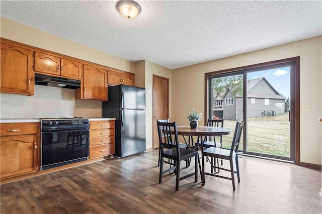 1109 Jeff Cir, Paola, KS 66071 - kitchen with freestanding refrigerator, range, under cabinet range hood, brown cabinets, and a textured ceiling