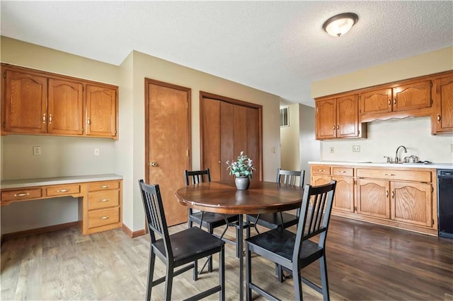 1109 Jeff Cir, Paola, KS 66071 - dining space featuring wood finished floors, a textured ceiling, and baseboards