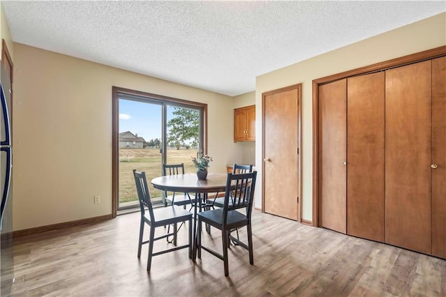 1109 Jeff Cir, Paola, KS 66071 - dining space featuring light wood-style flooring, a textured ceiling, and baseboards