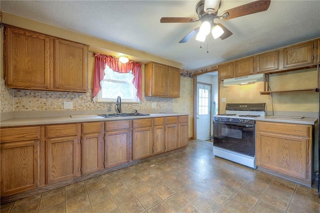 8713 Old Stagecoach Rd, Kansas City, MO 64154 - kitchen featuring gas range oven, a sink, under cabinet range hood, light countertops, and a textured ceiling