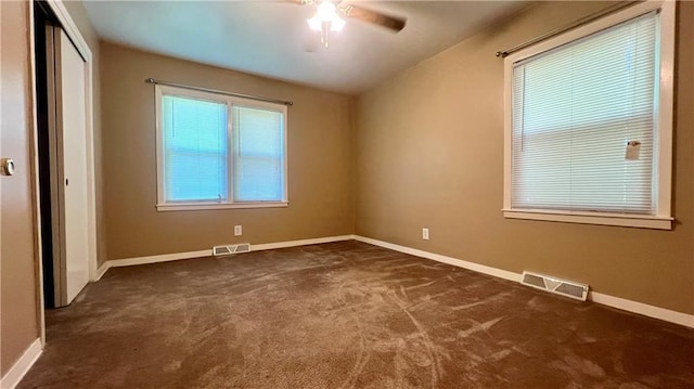 1445 E 77th St, Kansas City, MO 64131 - unfurnished room featuring dark carpet, ceiling fan, and healthy amount of natural light