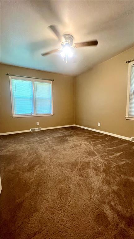 1445 E 77th St, Kansas City, MO 64131 - carpeted empty room with a ceiling fan and healthy amount of natural light