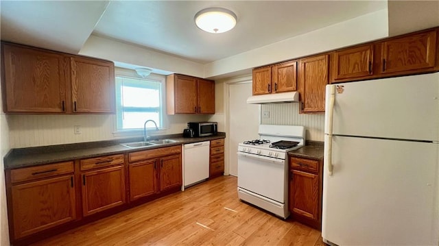1445 E 77th St, Kansas City, MO 64131 - kitchen featuring white appliances, under cabinet range hood, dark countertops, brown cabinetry, and light wood-style floors